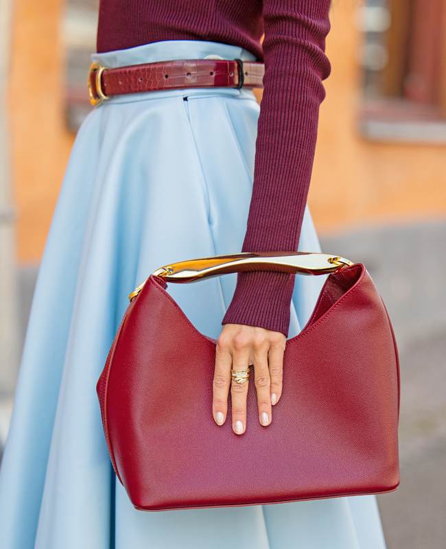Frau trägt elegante Red-Wine-Bag lässig in der Hand