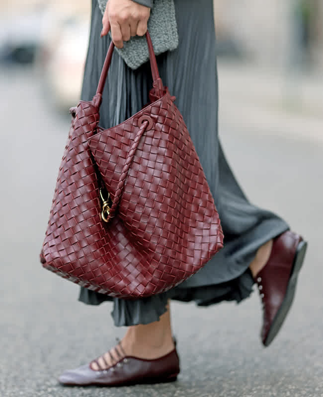 Person trägt dunkelrote XXL-Handtasche als Hingucker zu lässigem Alltags-Outfit 