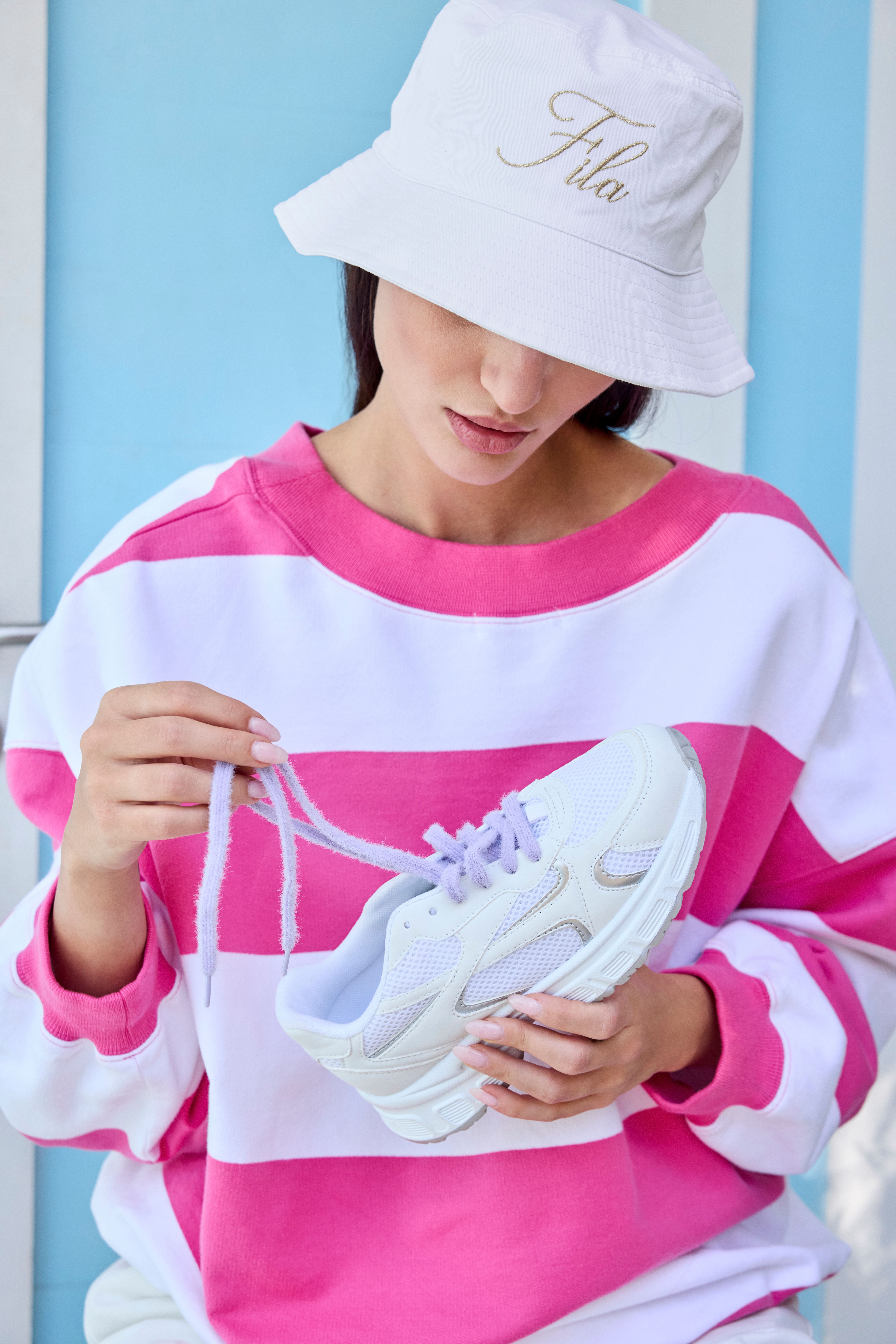 Frau mit weiß-pink-gestreiften Pullover und weißem Fischerhut