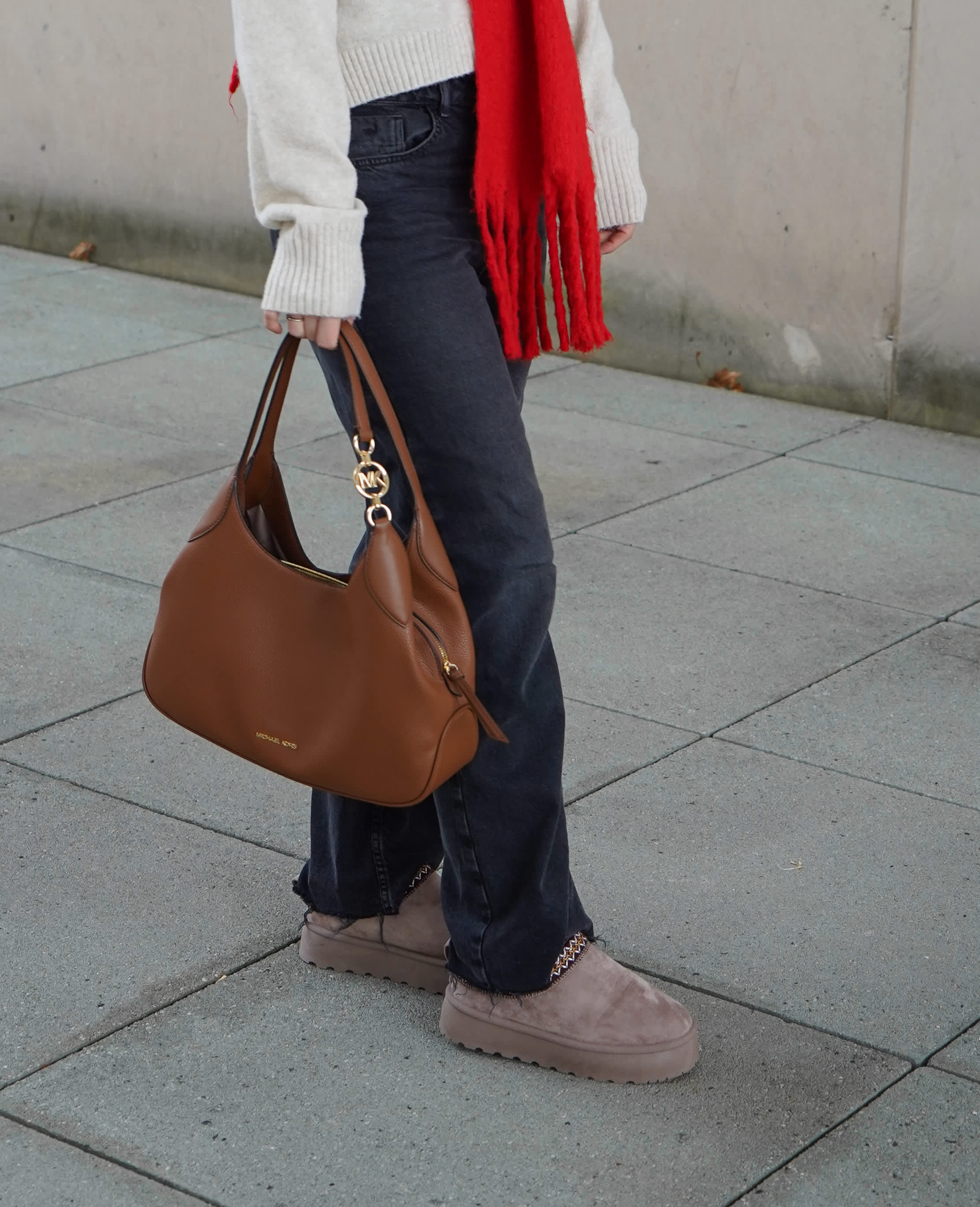 Nahaufnahme einer Person in Cozy-Style-Basics, mit lässiger Jeans und Pantoletten