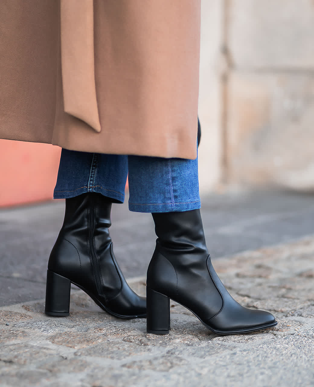 Close-Up einer Frau, die schwarze Stiefeletten zu einer blauen Jeans trägt