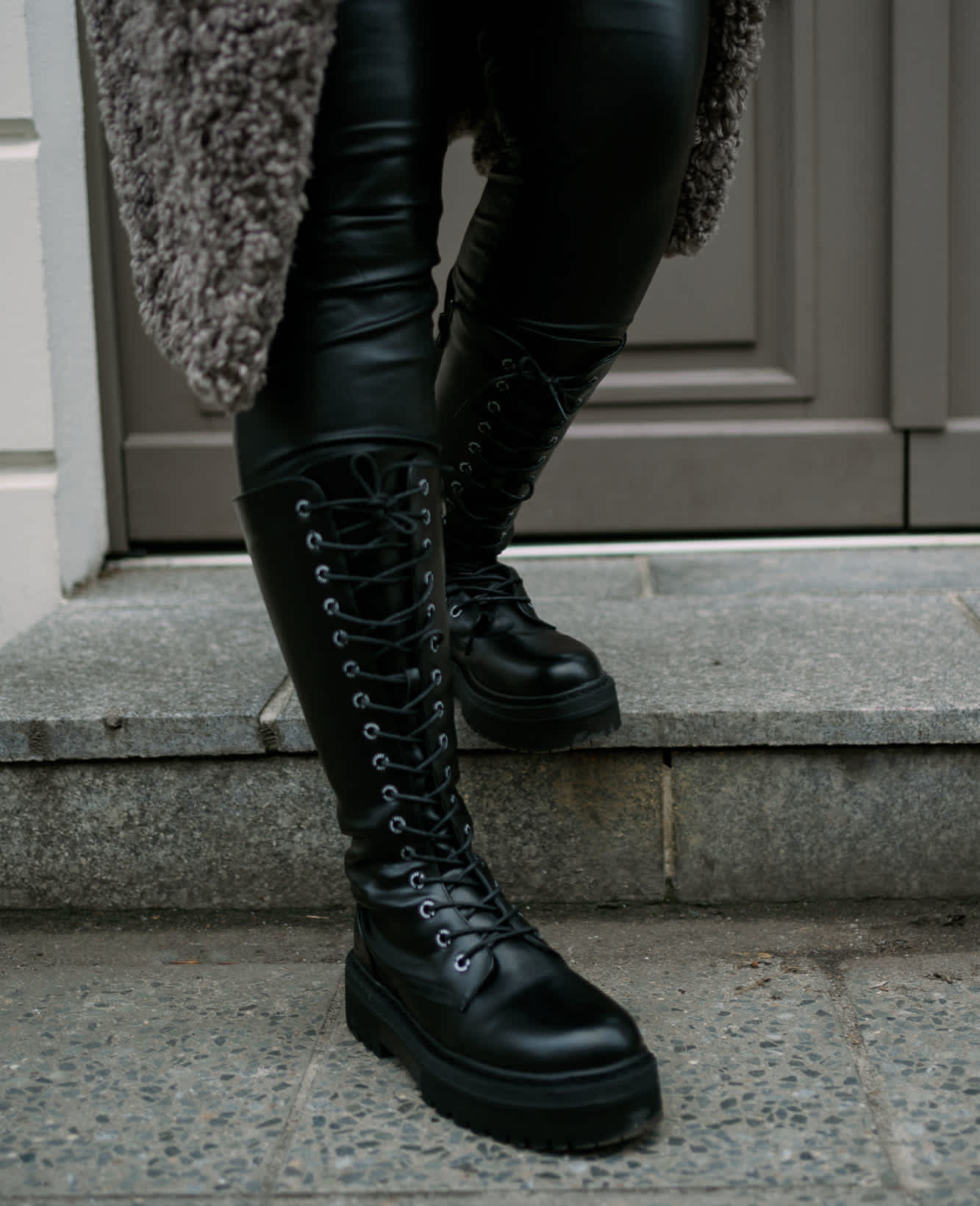 Nahaufnahme schwarzer Dockers Schnürstiefel von DEICHMANN, vor einem Treppenabsatz