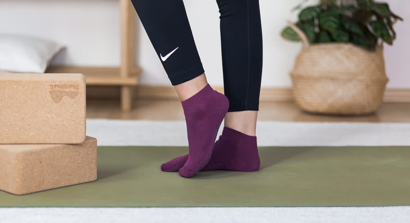 Nahaufnahme einer Person, die auf einer grünen Yogamatte steht