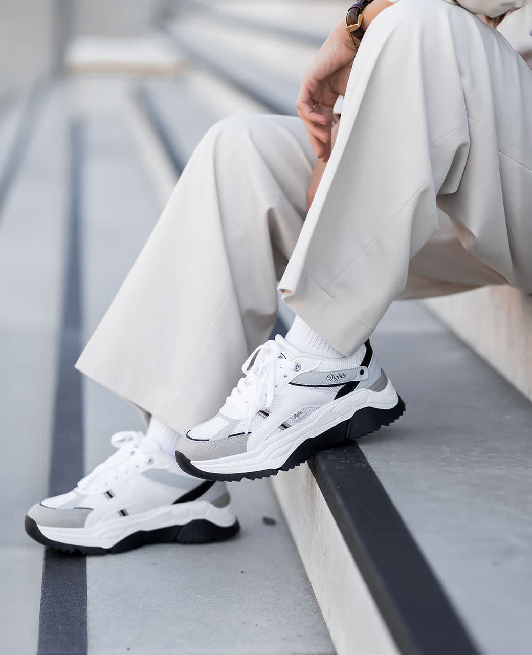 Nahaufnahme weißer Sneaker in Kombination mit einem weißen Zweiteiler