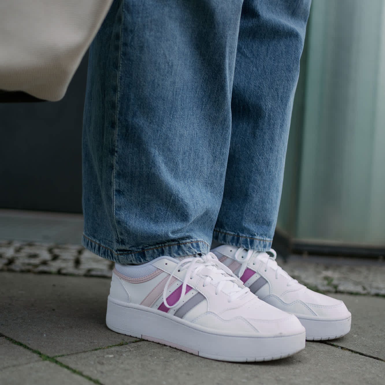 Weiße Sneaker-Schuhe zu weiten Hosen 