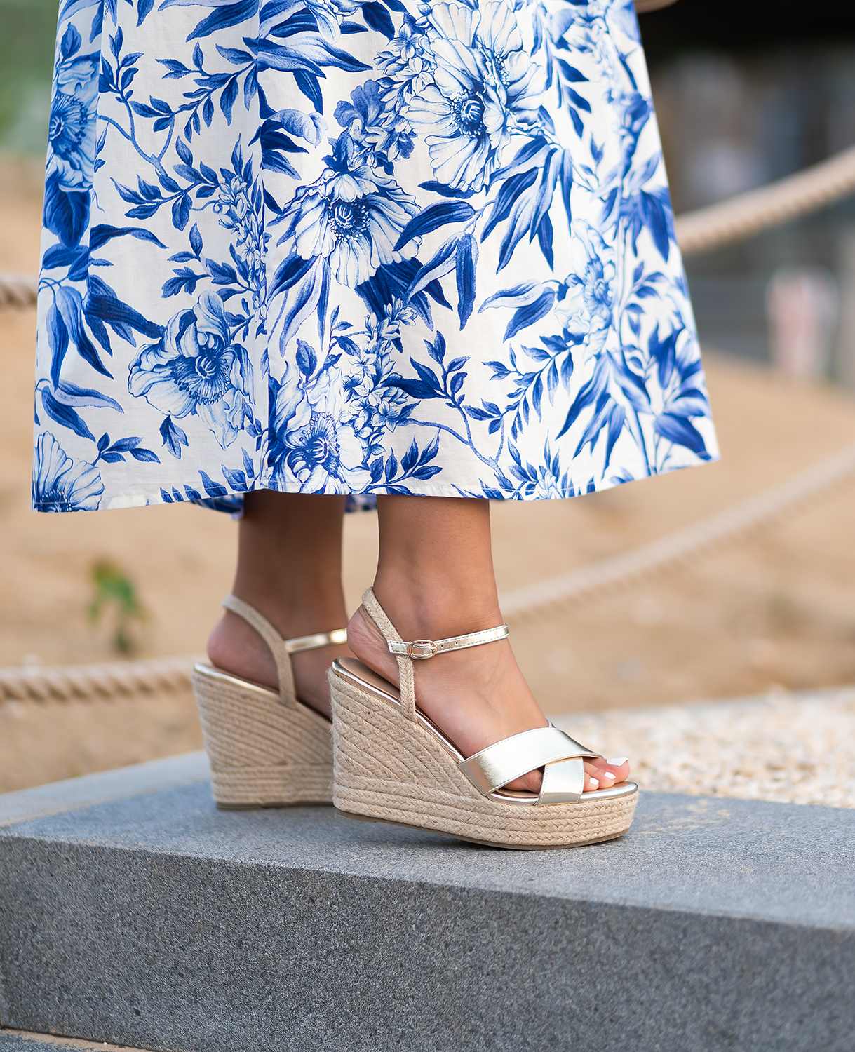 Frau präsentiert Strandoutfit, Kombination aus blauem Sommerkleid mit Keilsandaletten