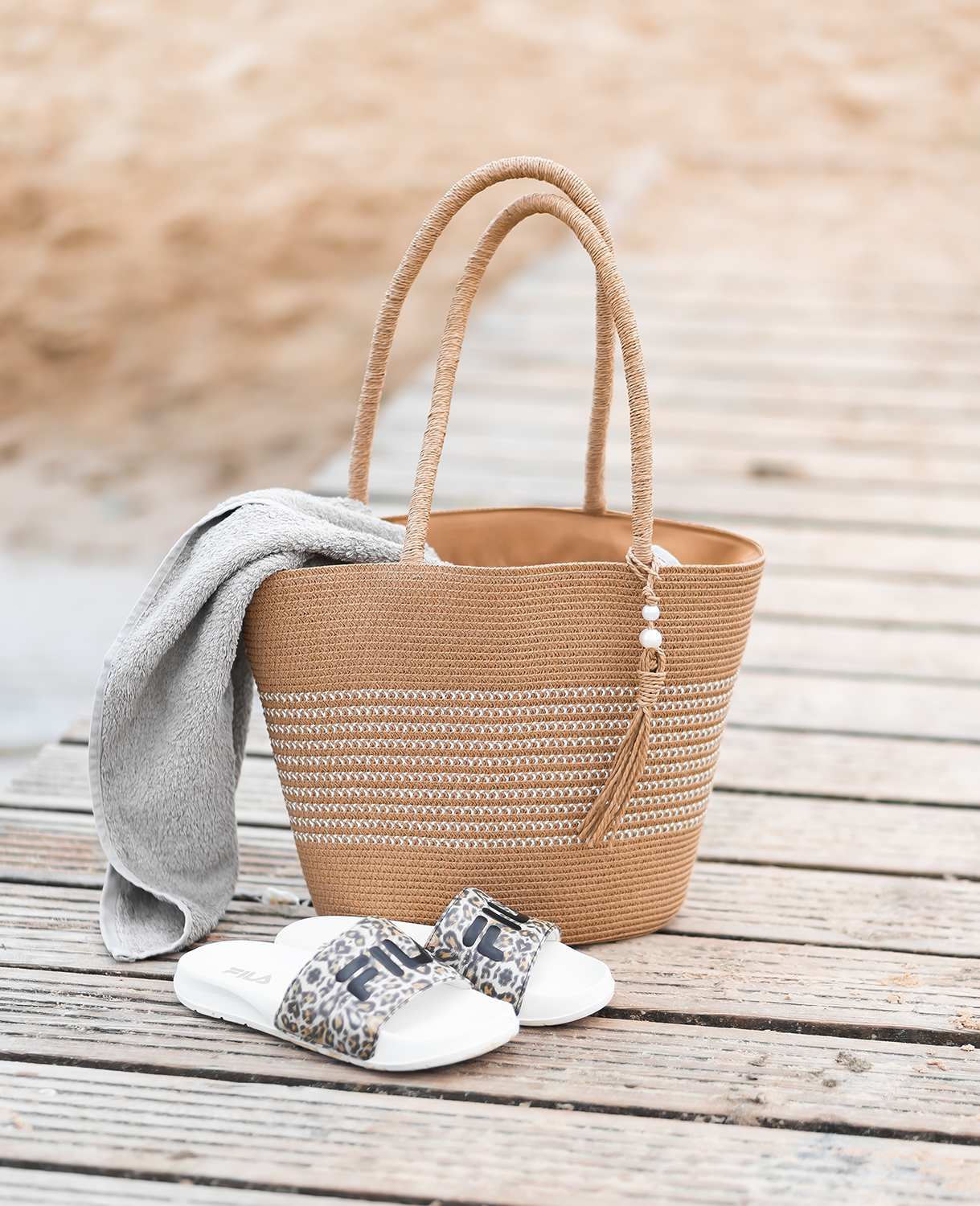 Braune Basttasche als Strandkorb auf Badesteg, Pool Slides im Vordergrund