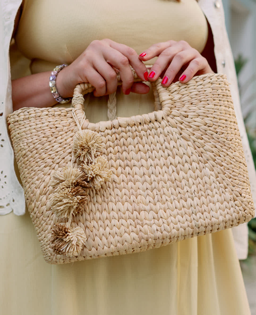 Nahaufnahme Details Outfit, Boho-Tasche und lackierte Fingernägel