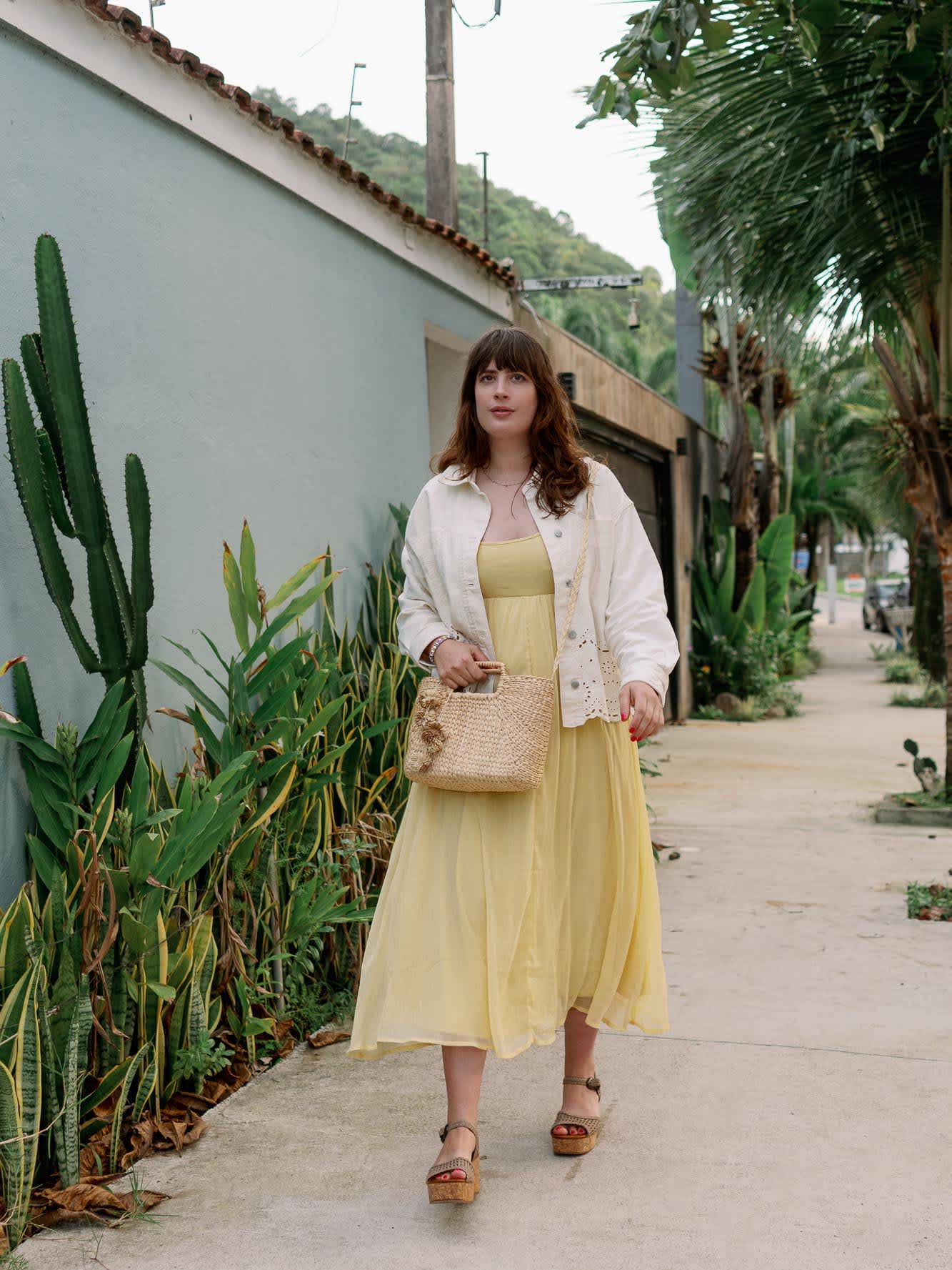 Aufnahme des gesamten Outfits, ein warmer sommerlicher Look mit gelbem Kleid und Keilsandaletten
