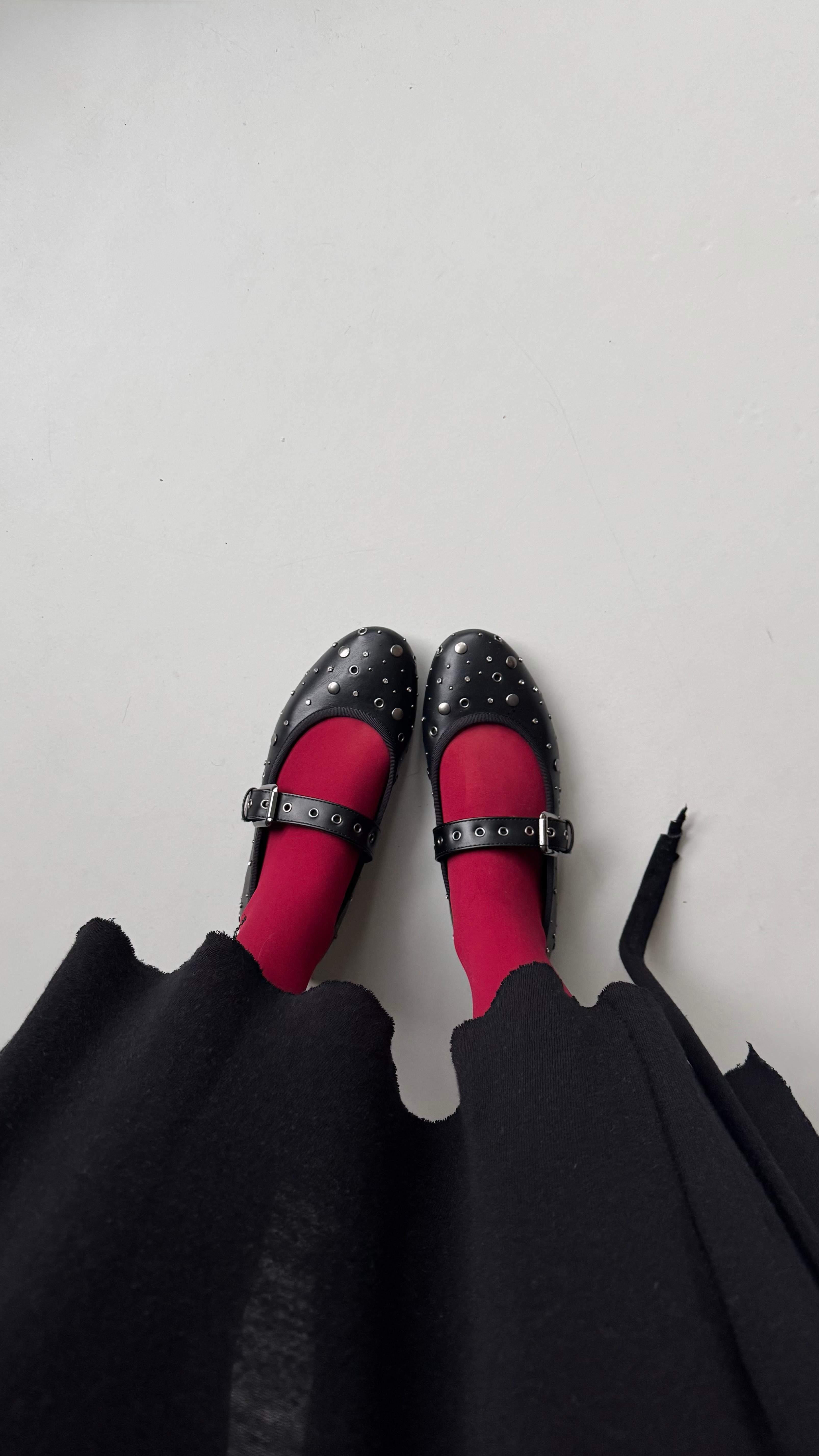 Top-Down Ansicht einer Person auf ihre schwarzen Ballerinas