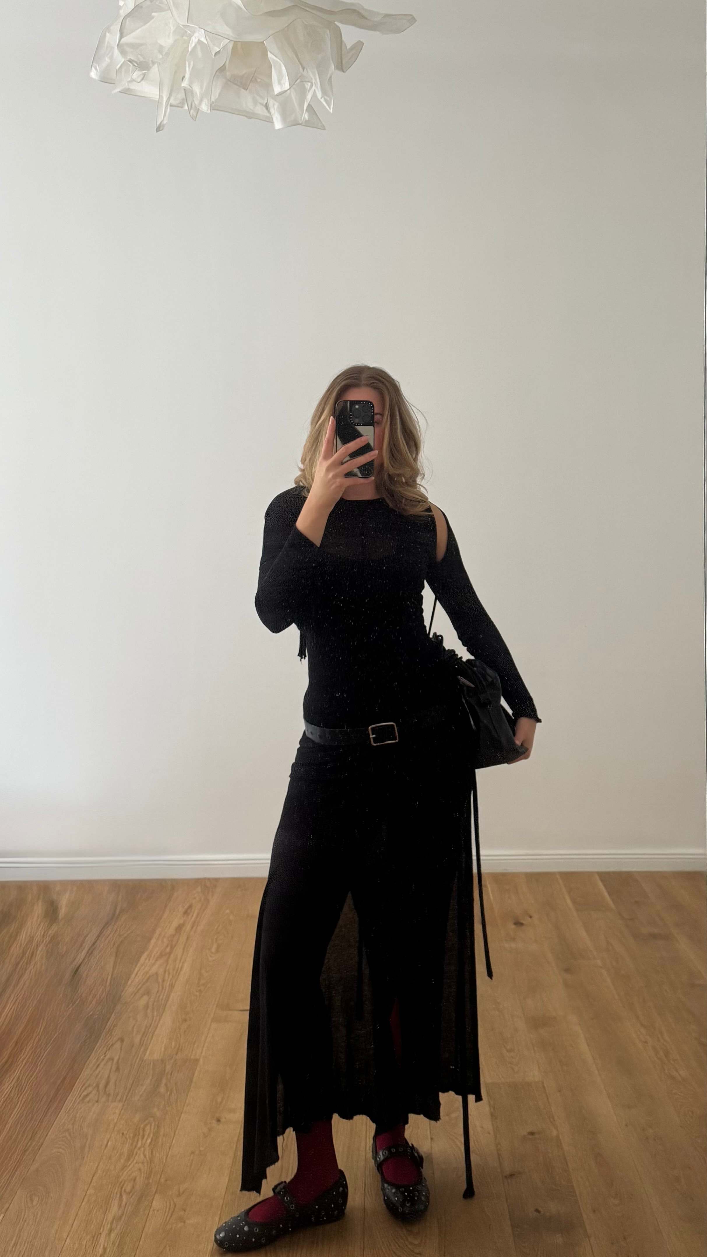 Junge Frau macht Selfie, gekleidet in schwarzes Balletcore-Outfit