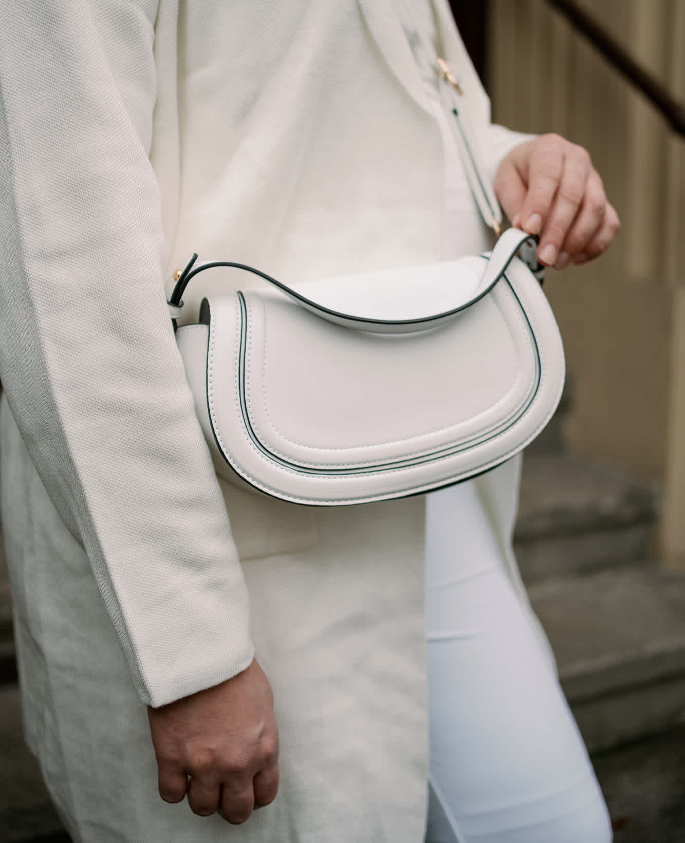 Frau trägt weiße Umhängetasche in schlichtem Design