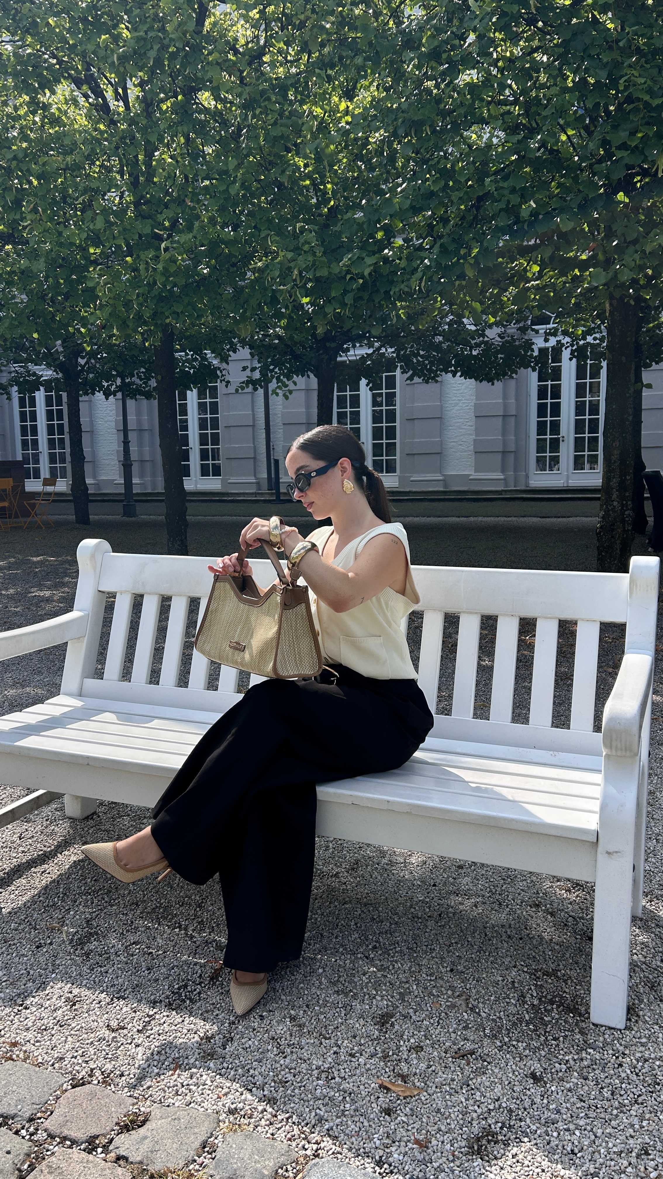 Frau trägt ein Old Money Outfit mit cremefarbener Weste