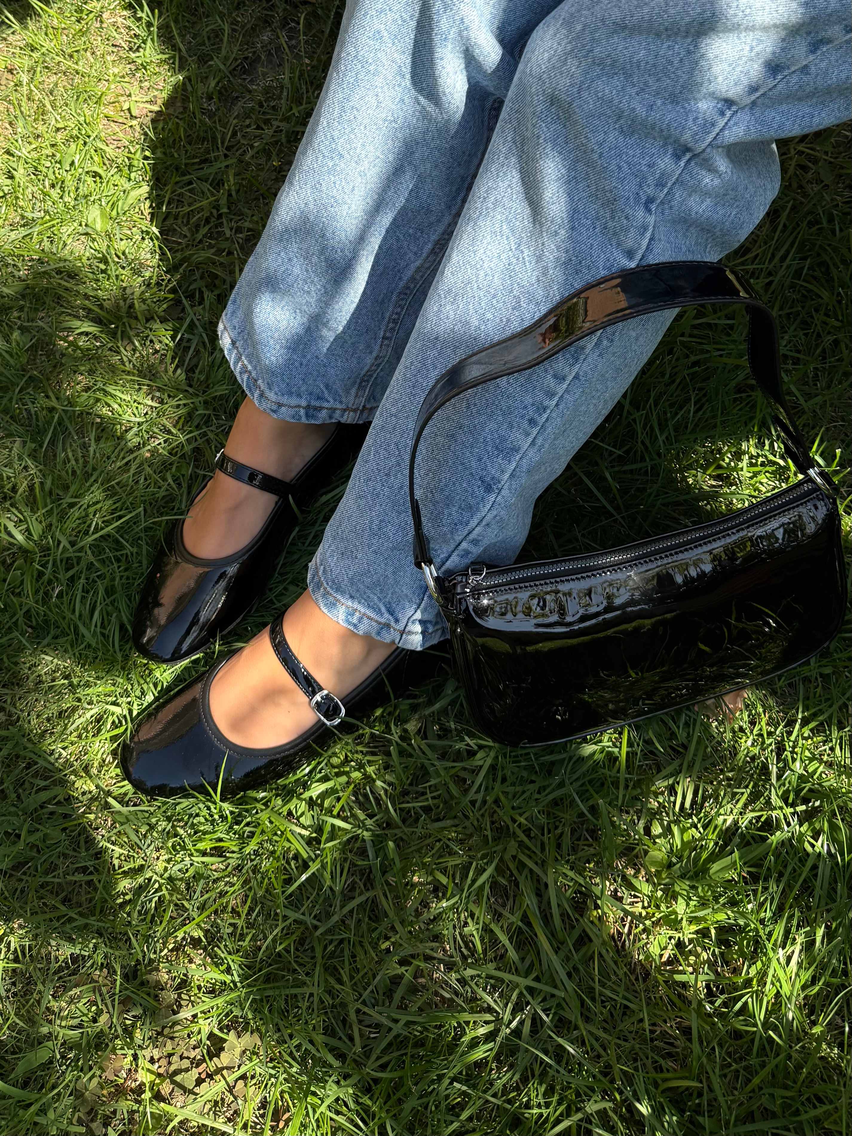 Frau trägt schwarze Mary Jane-Pumps zu Jeanshose als Gartenoutfit, Close-Up
