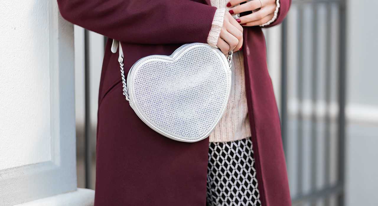 Frau trägt Handtasche in Herzform als Accessoire