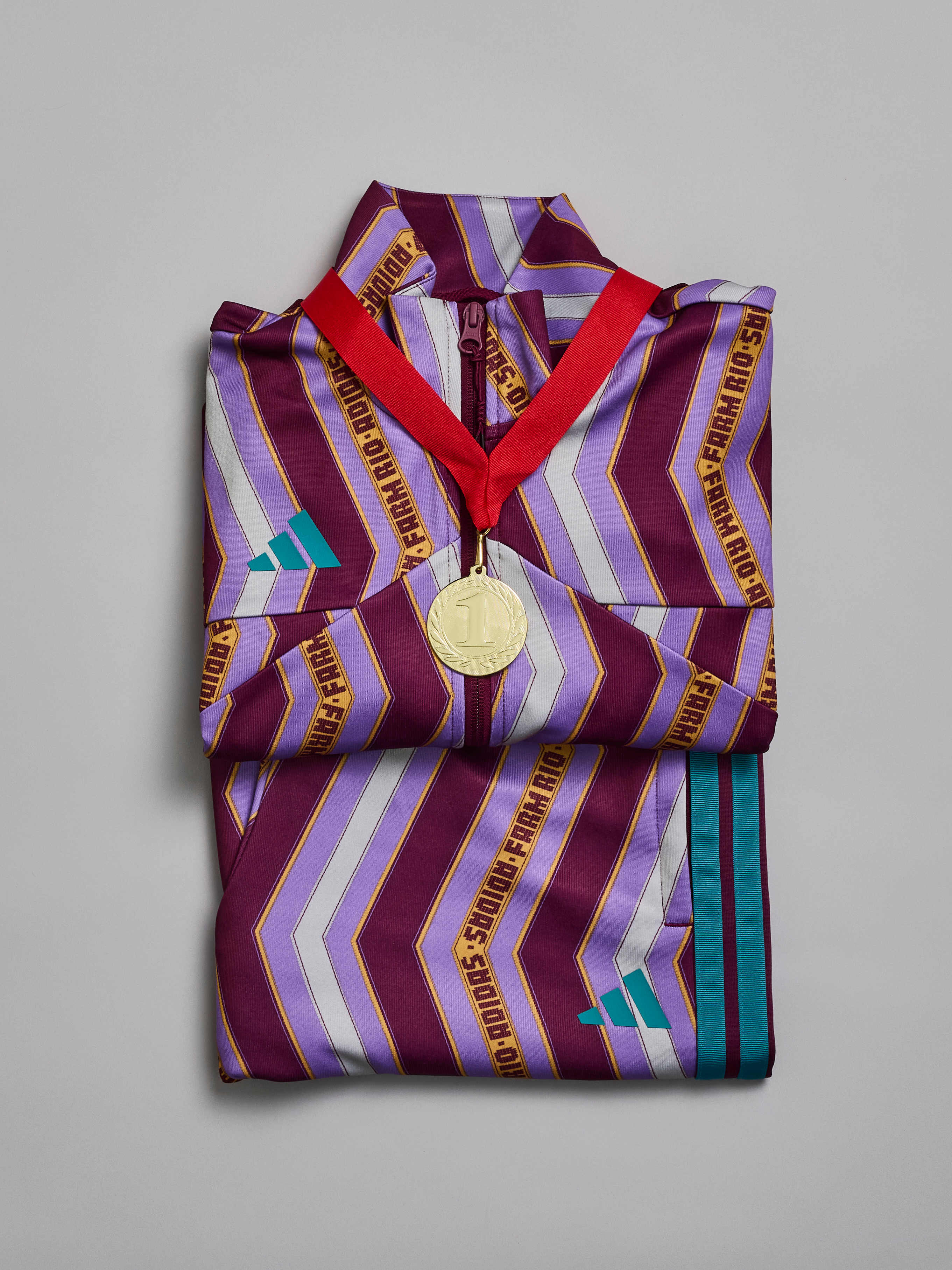 Sportliches Outfit, gefaltet am Boden, mit einer Medaille