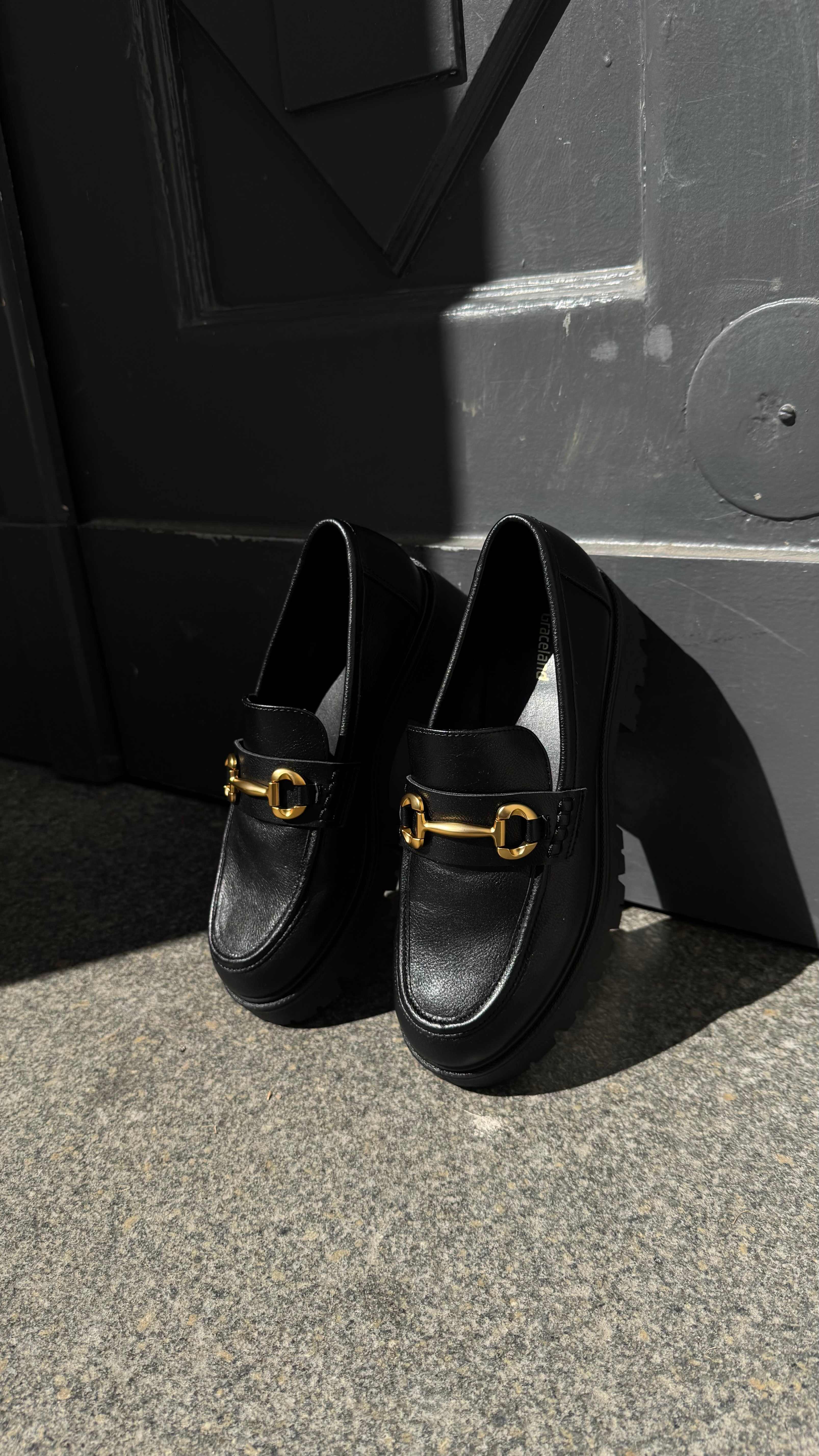 Ein Paar schwarzer Dandy Schuhe mit Goldschnallen 