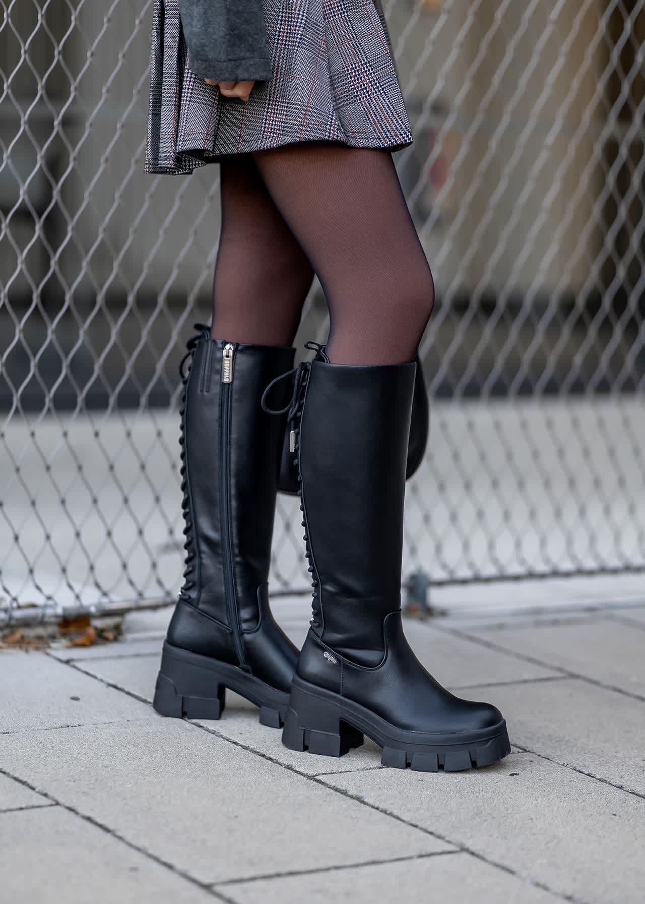 Close-Up einer Frau mit schwarzen Underknees zum grauen Rock