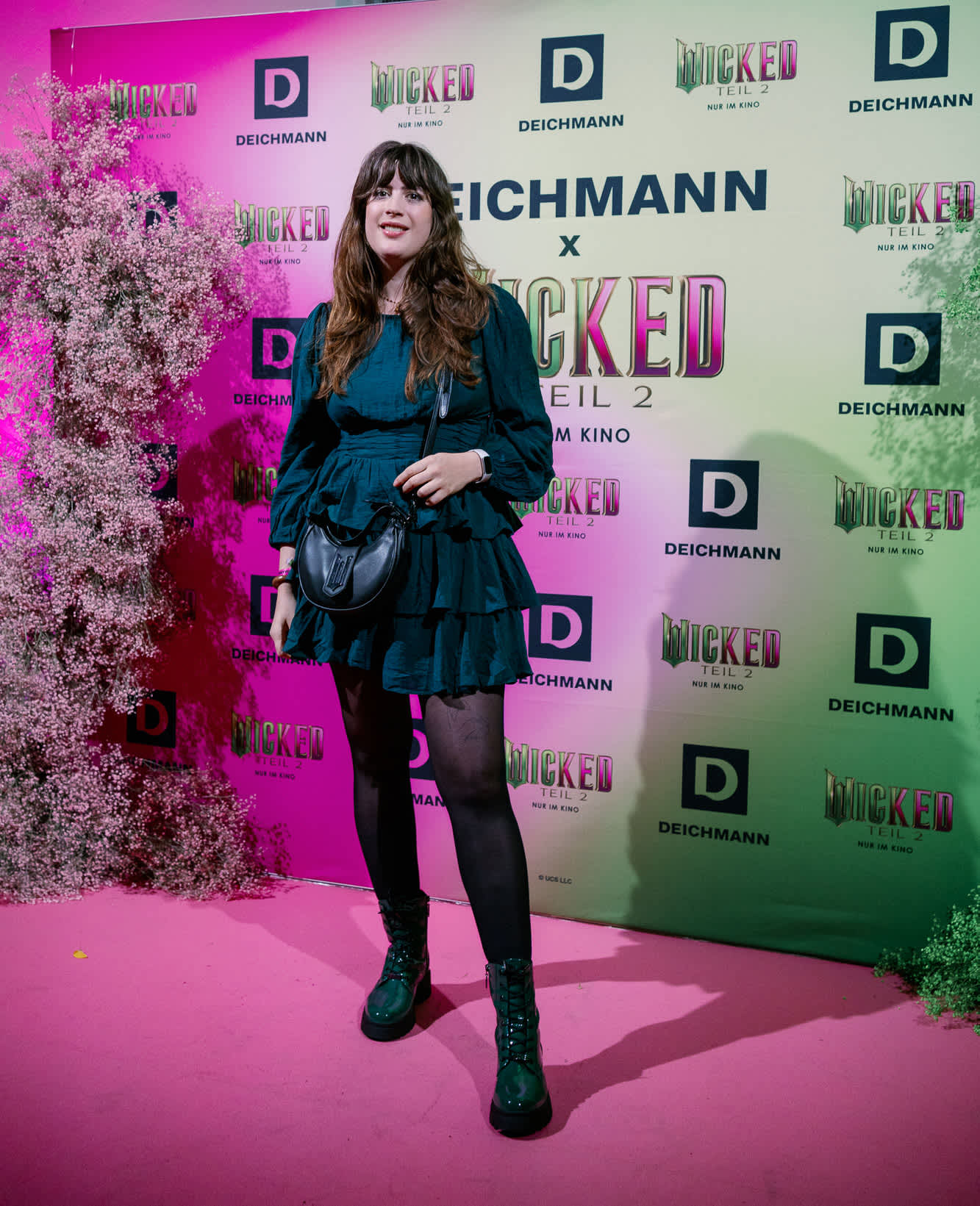 Frau steht auf Event vor Banner mit Deichmann- und Wicked-Schriftzügen