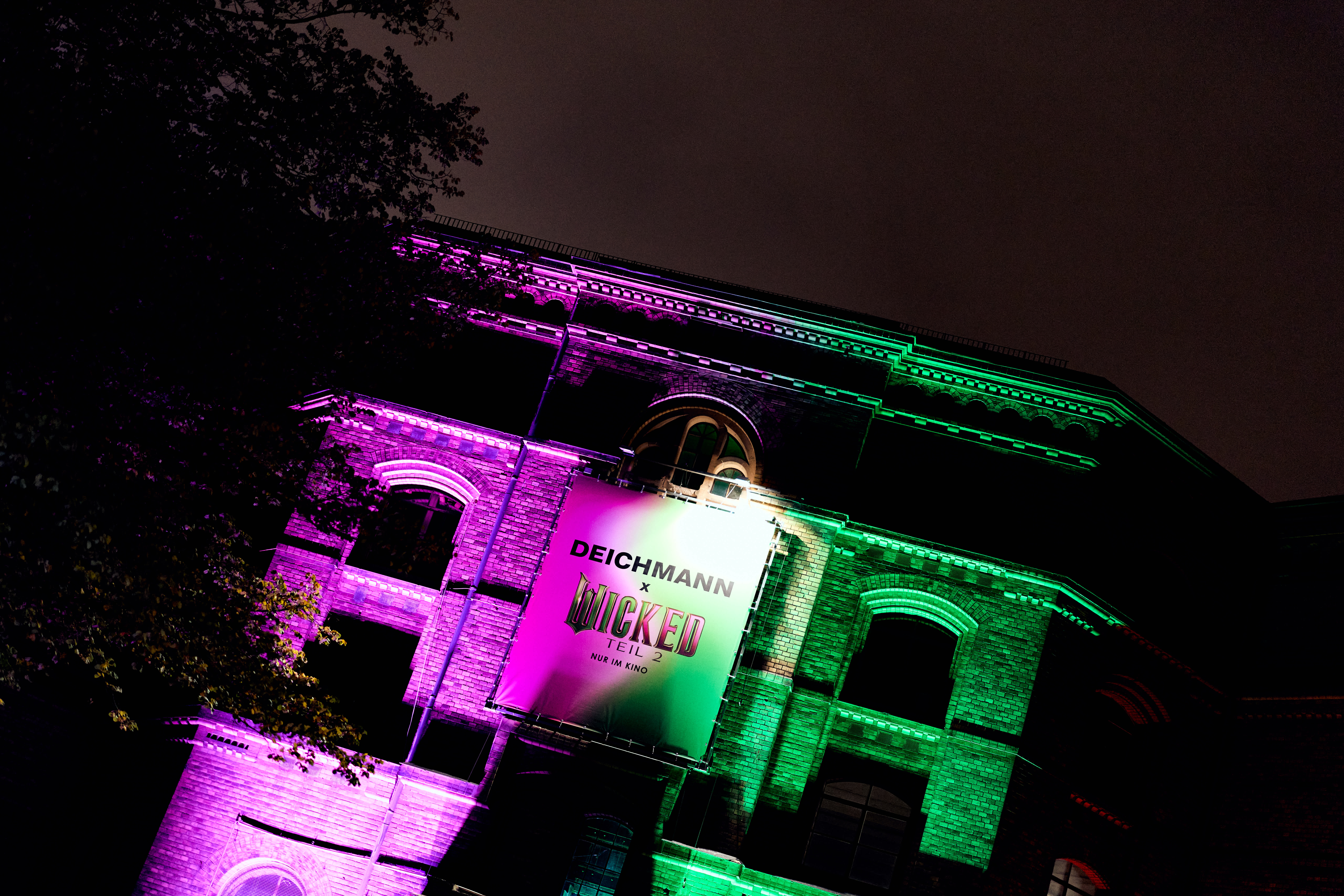 Gebäude mit Deichmann x Wicked-Banner in den Filmfarben