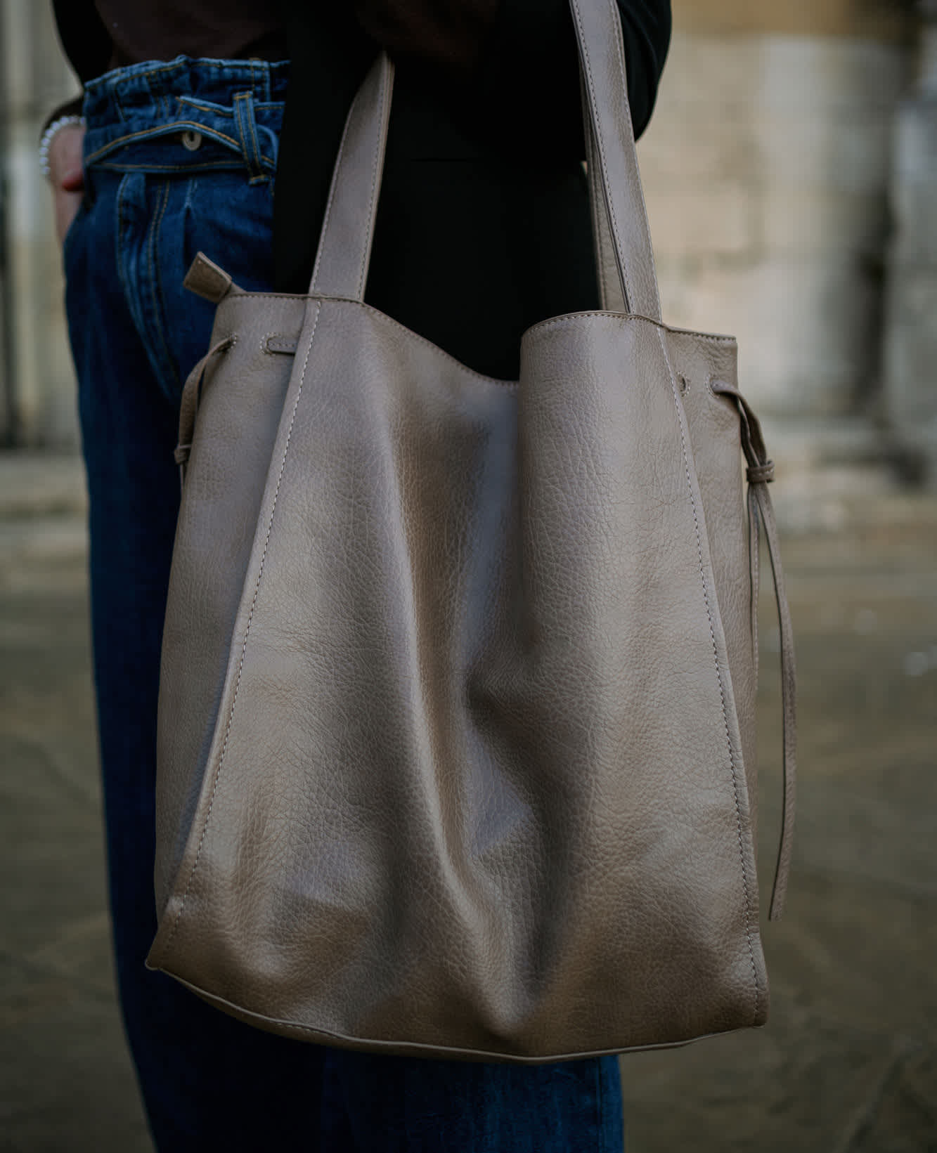 Frau trägt graue Shopper-Handtasche an ihrem Arm