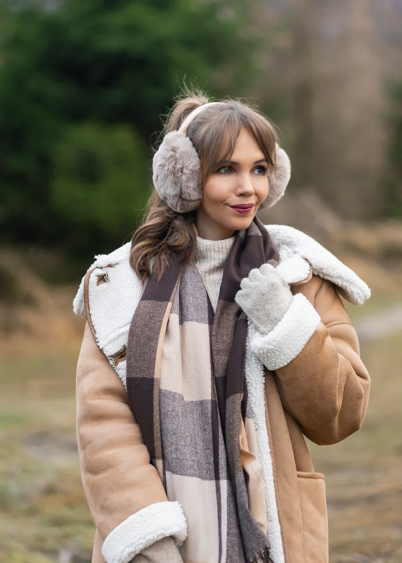 Frau trägt flauschige Ohrenwärmer in Grau zu kuscheligem Coat