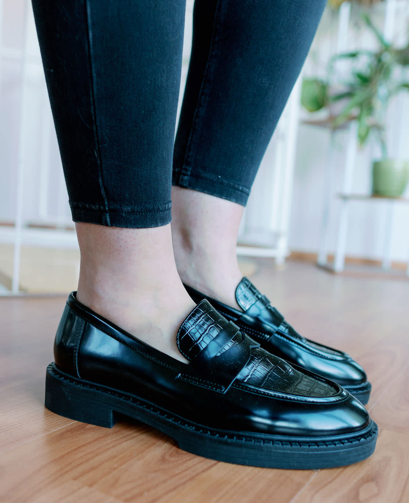 Frau in schwarz-glänzenden Dandy Sneakern