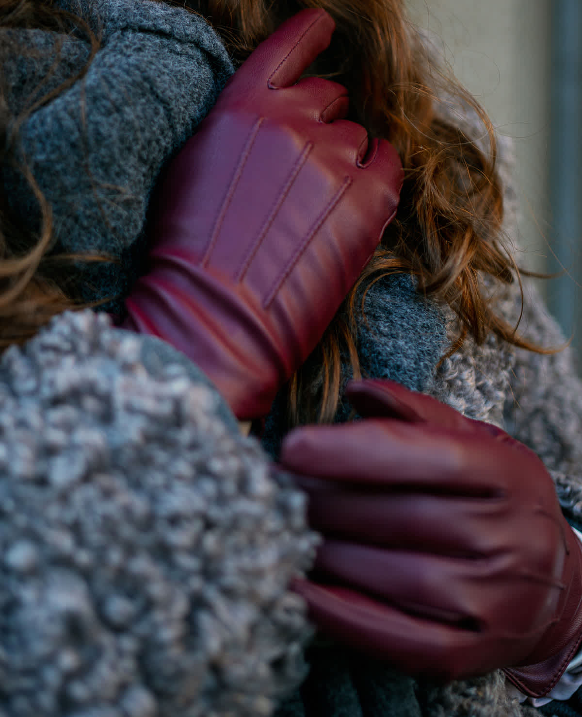 Frau trägt bordeaxrote Handschuhe als Akzent zum Outfit