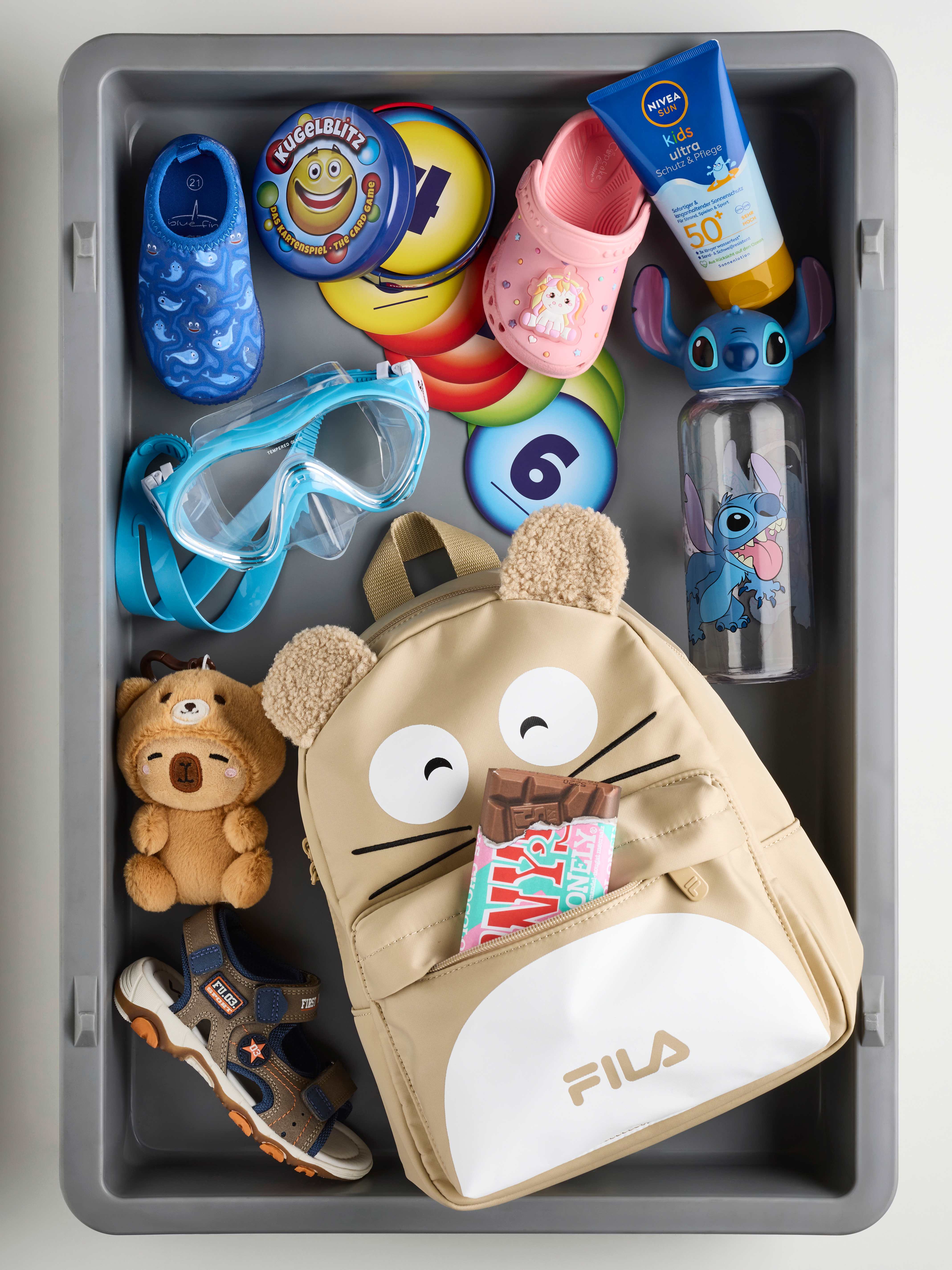 Kindersachen und Spielzeug in einem Airport-Bin