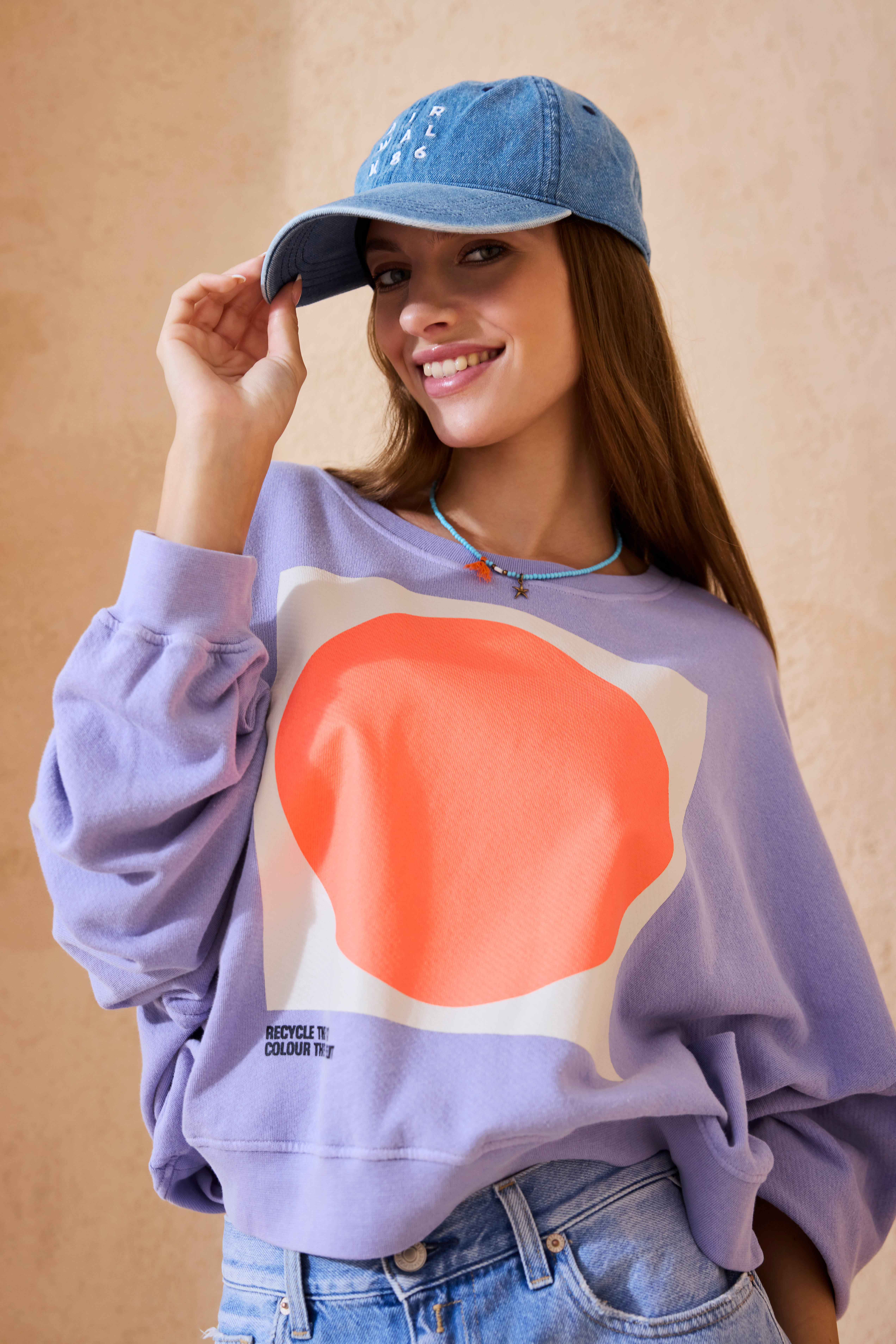 Lächelnde Frau mit T-Shirt und hellblauer Cap