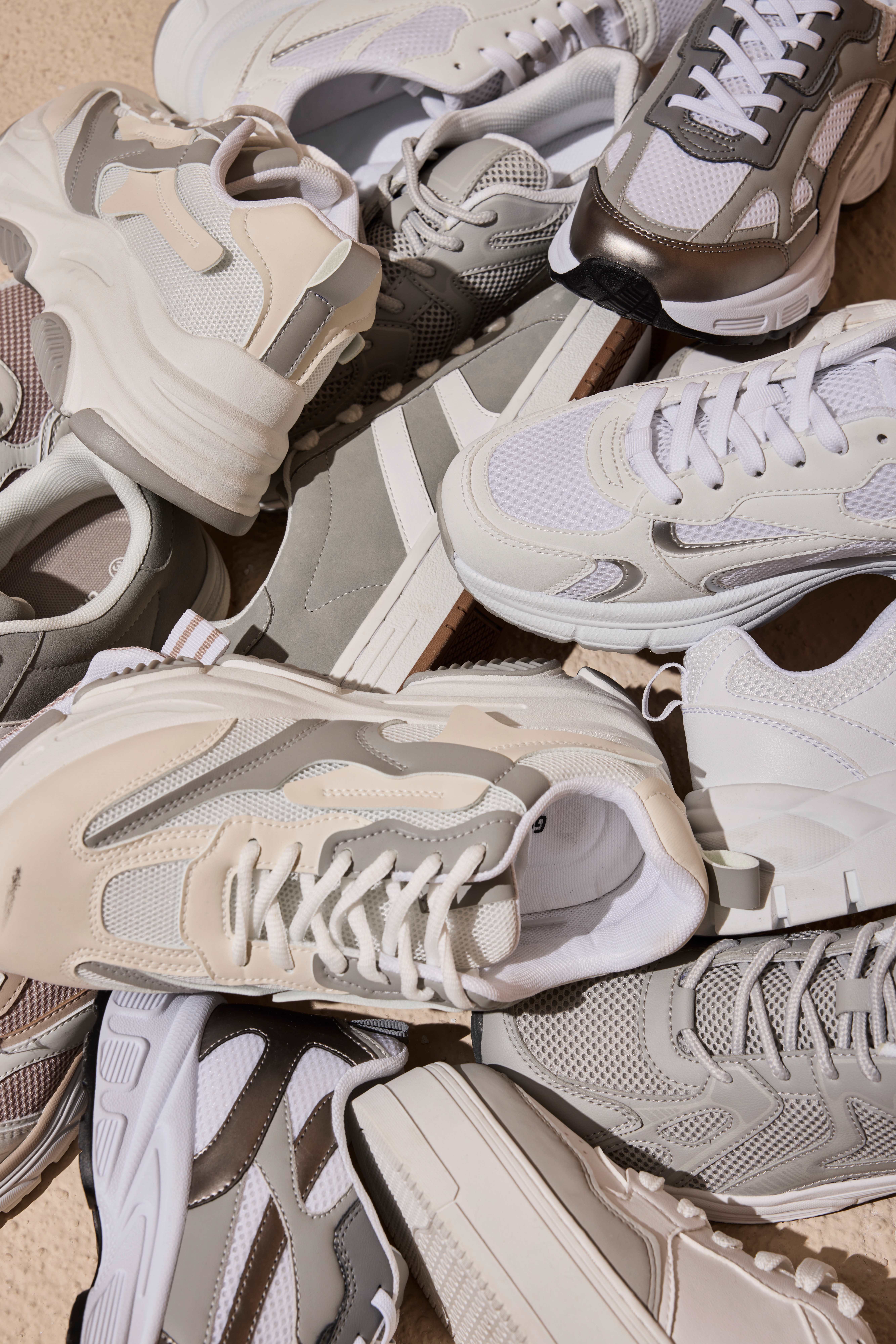 Ein Haufen unaufgeräumter weißer Sneaker, die übereinander liegen
