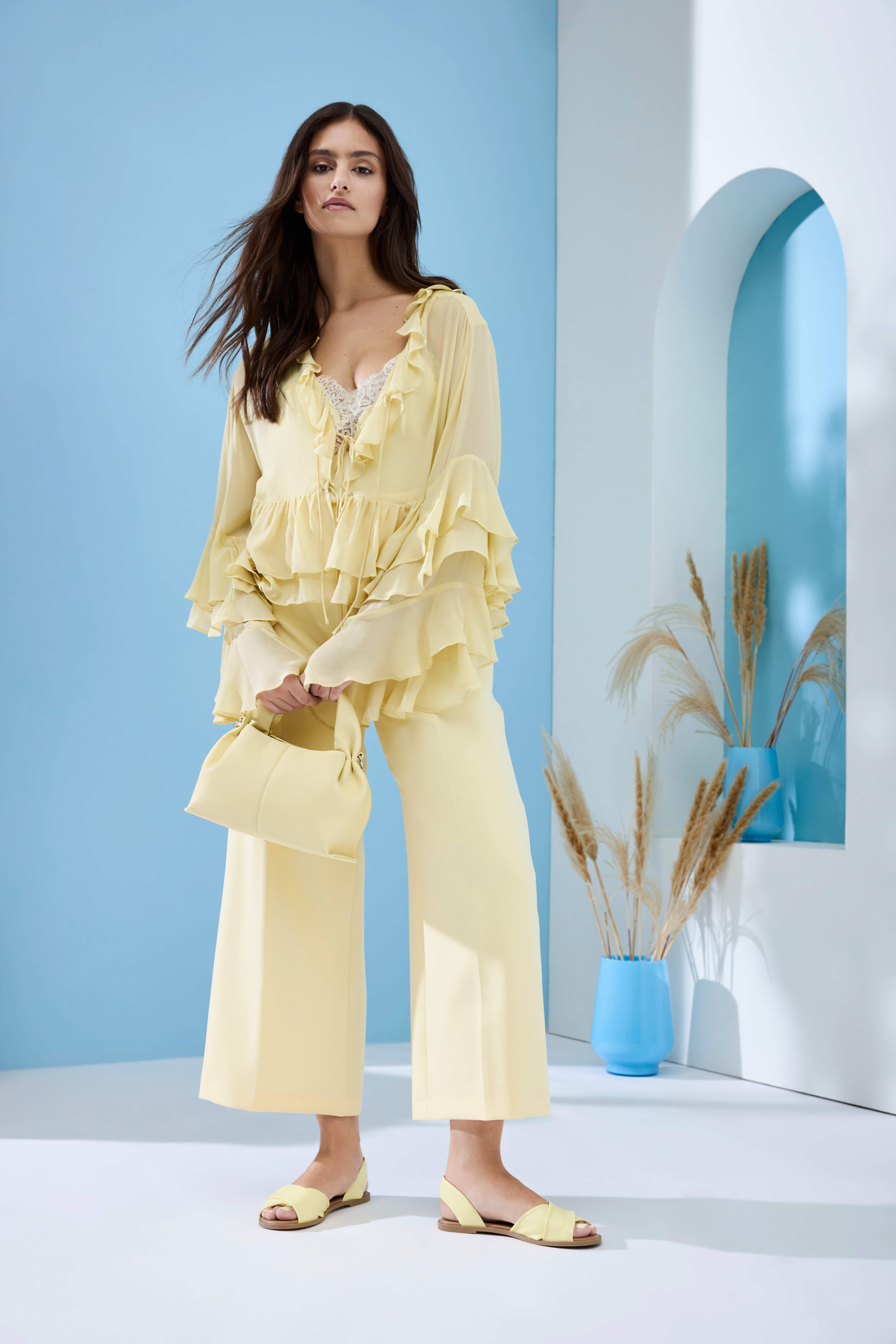 Schwarzhaarige Frau mit Rüschen-Top und Culotte in Butter Yellow