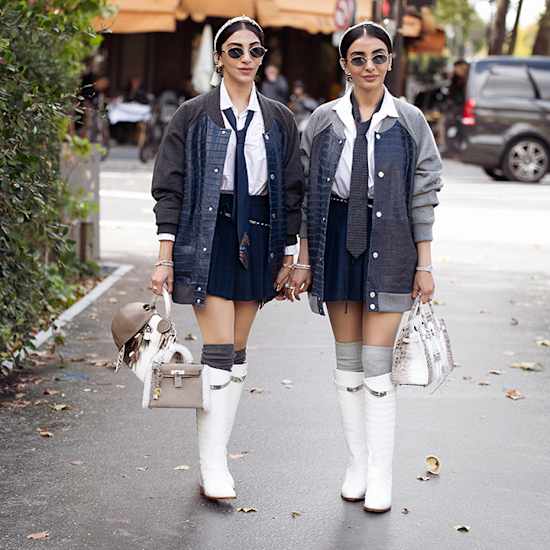 Zwei junge Damen im Preppy Look, denim-lastig, stehen auf Gehweg nebeneinander