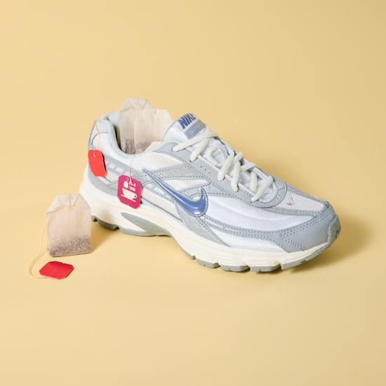 Weißer Sneaker-Schuh,, neben dem ein Teebeutel steht