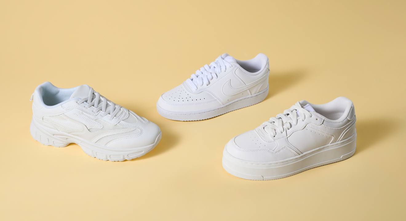 Drei sauber geputzte, weiße Sneaker stehen nebeneinander