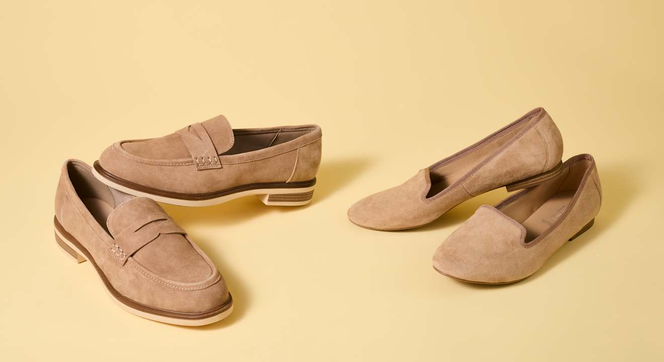 Vier einzelne Wildlederschuhe in Braun stehen nebeneinander auf dem Boden