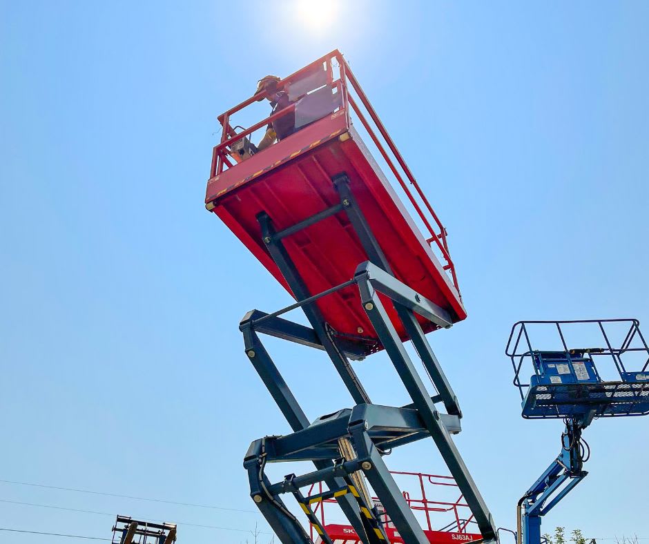 Scissor lift with a man on it extended at height