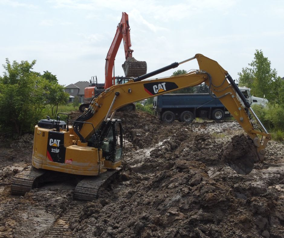 CAT 325 medium excavator moving dirt