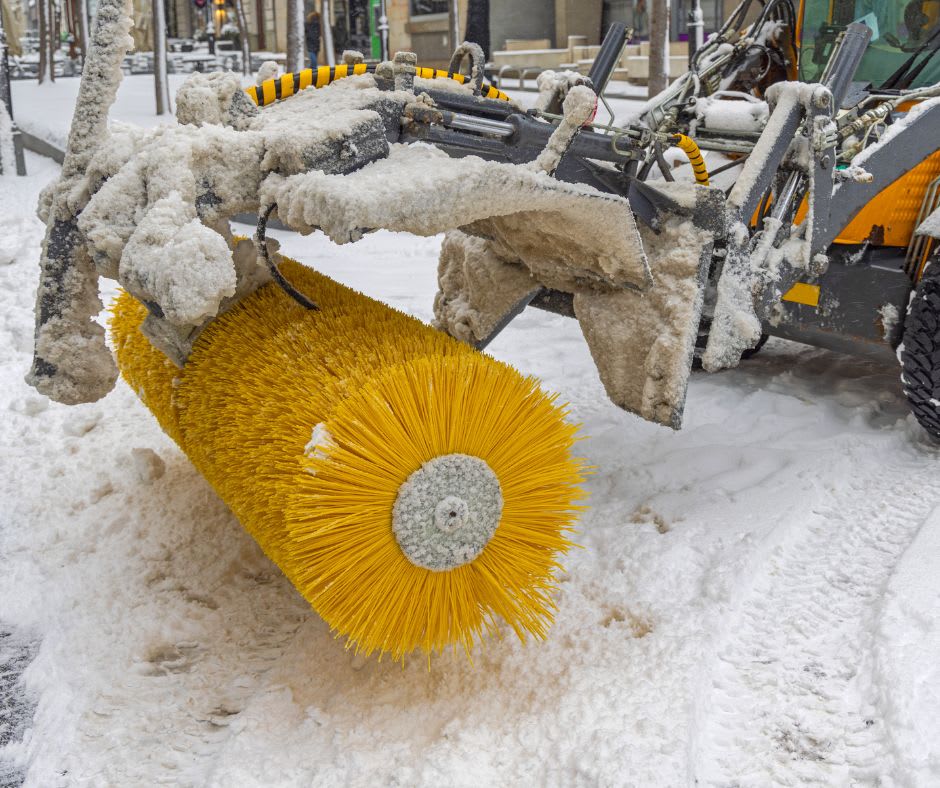 Broom attachment on a backhoe