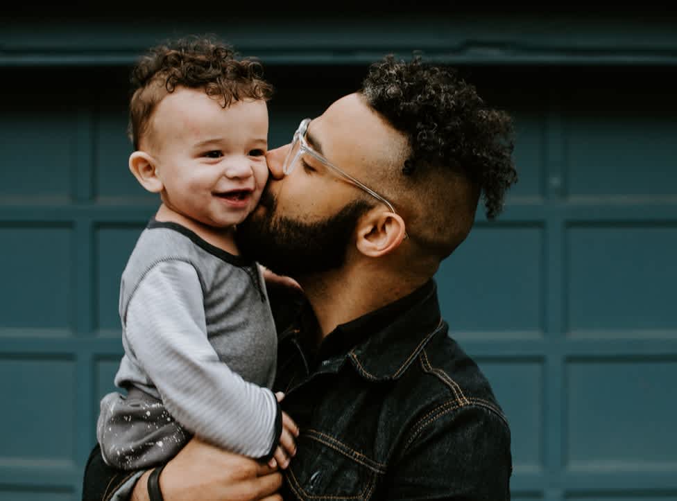 Dad kissing baby