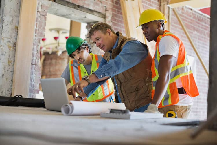 construction workers looking at laptop