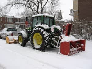 tractor with snow blower attachment in the snow.