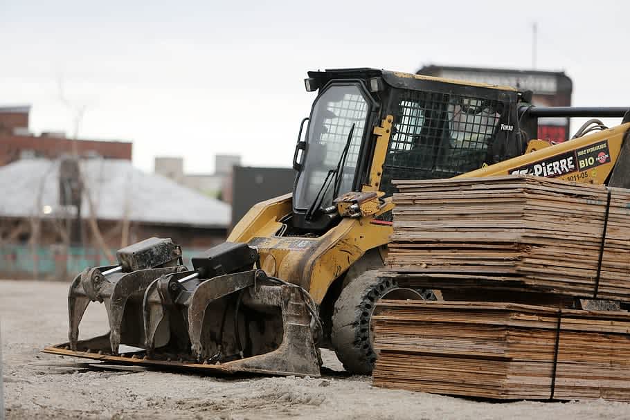 skid steer parked with palet attachment