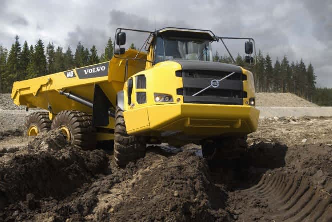 volvo construction rock truck driving over piles of dirt
