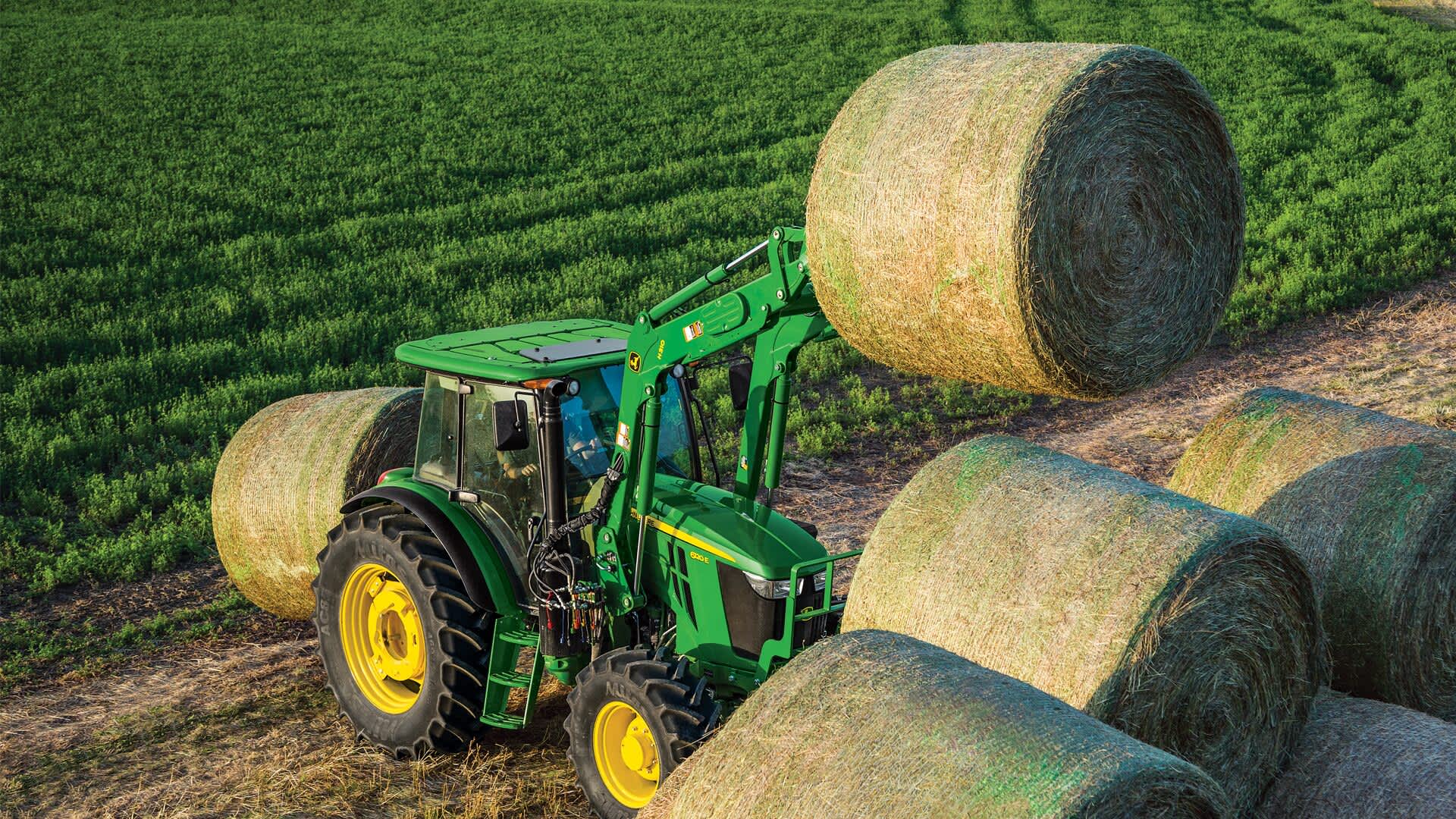 tractor lifting hay bale