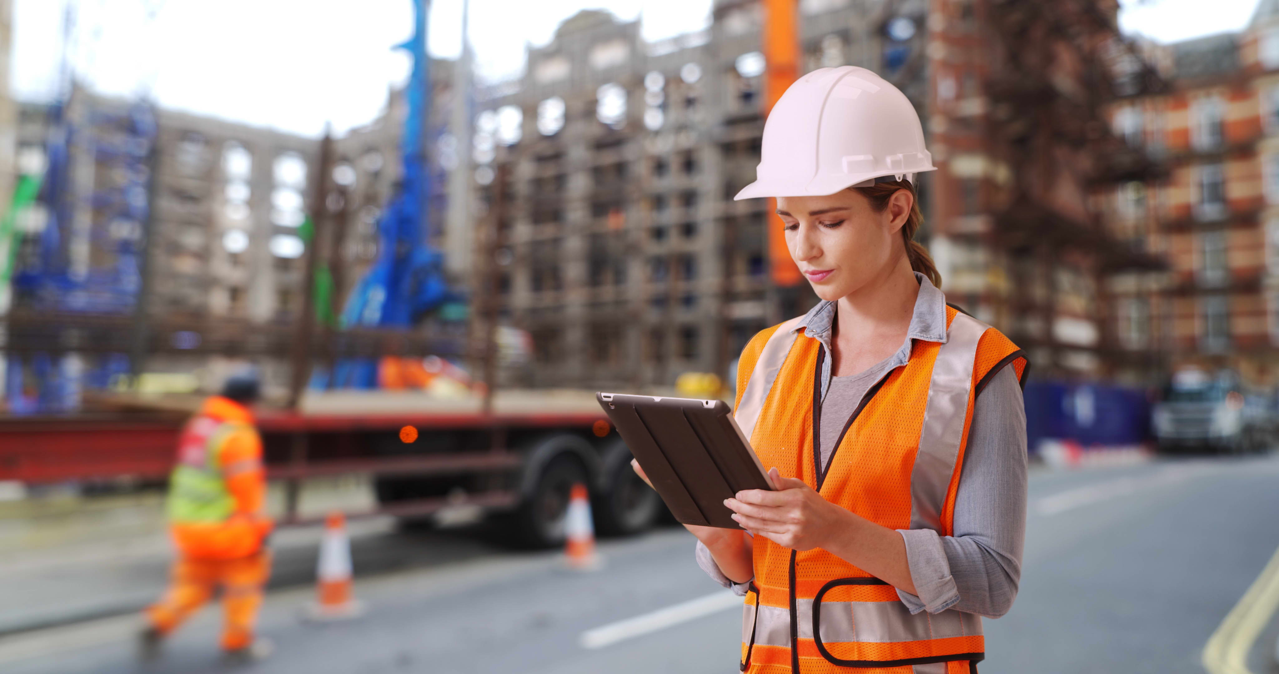 woman on construction site looking at tablet