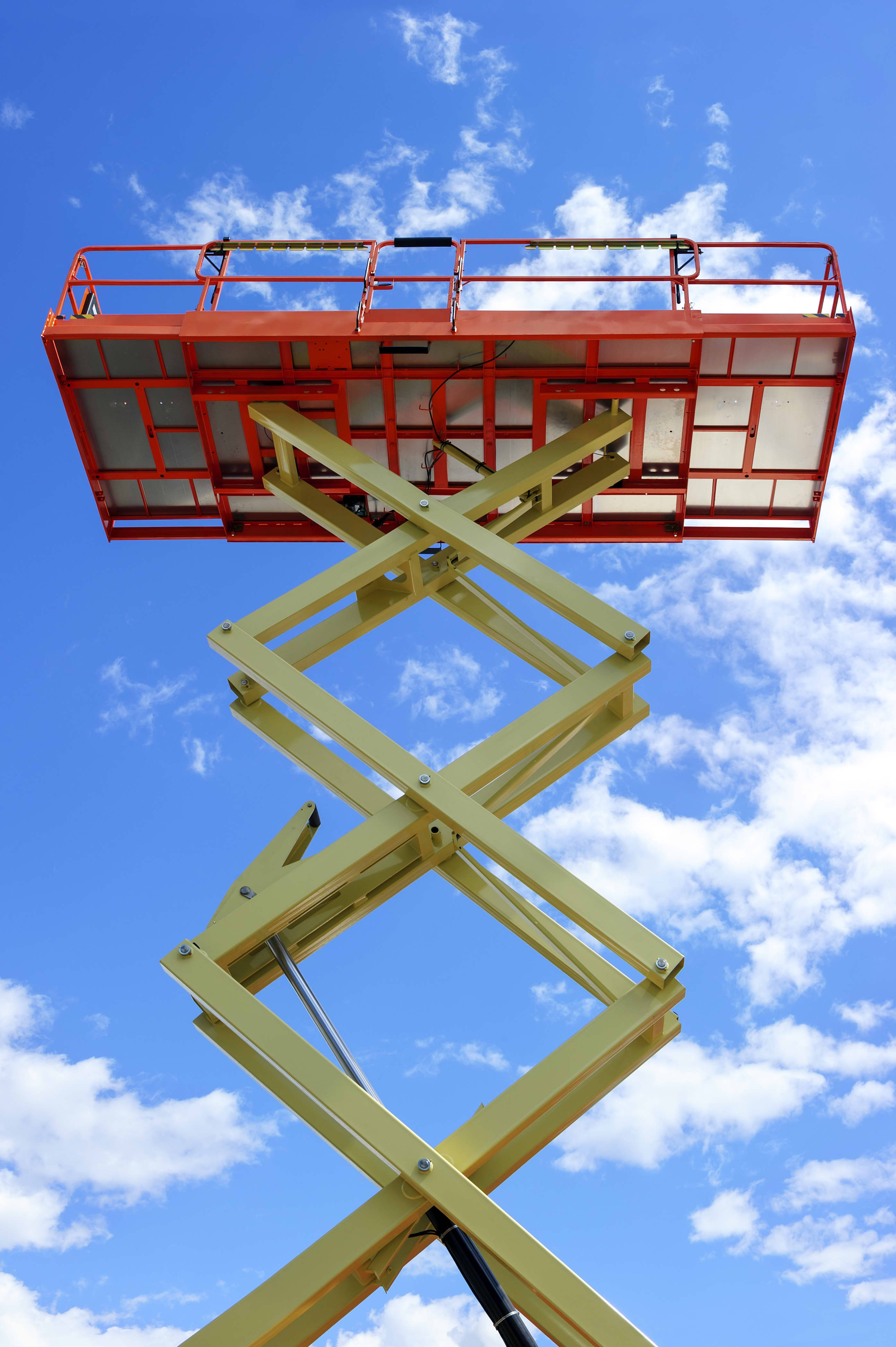 Scissor lift extended with blue sky in background