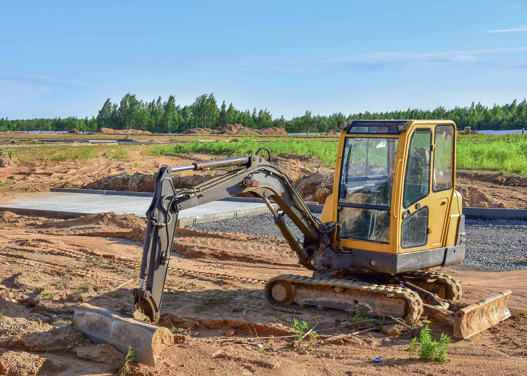 mini excavator with wide edge bucket attachment