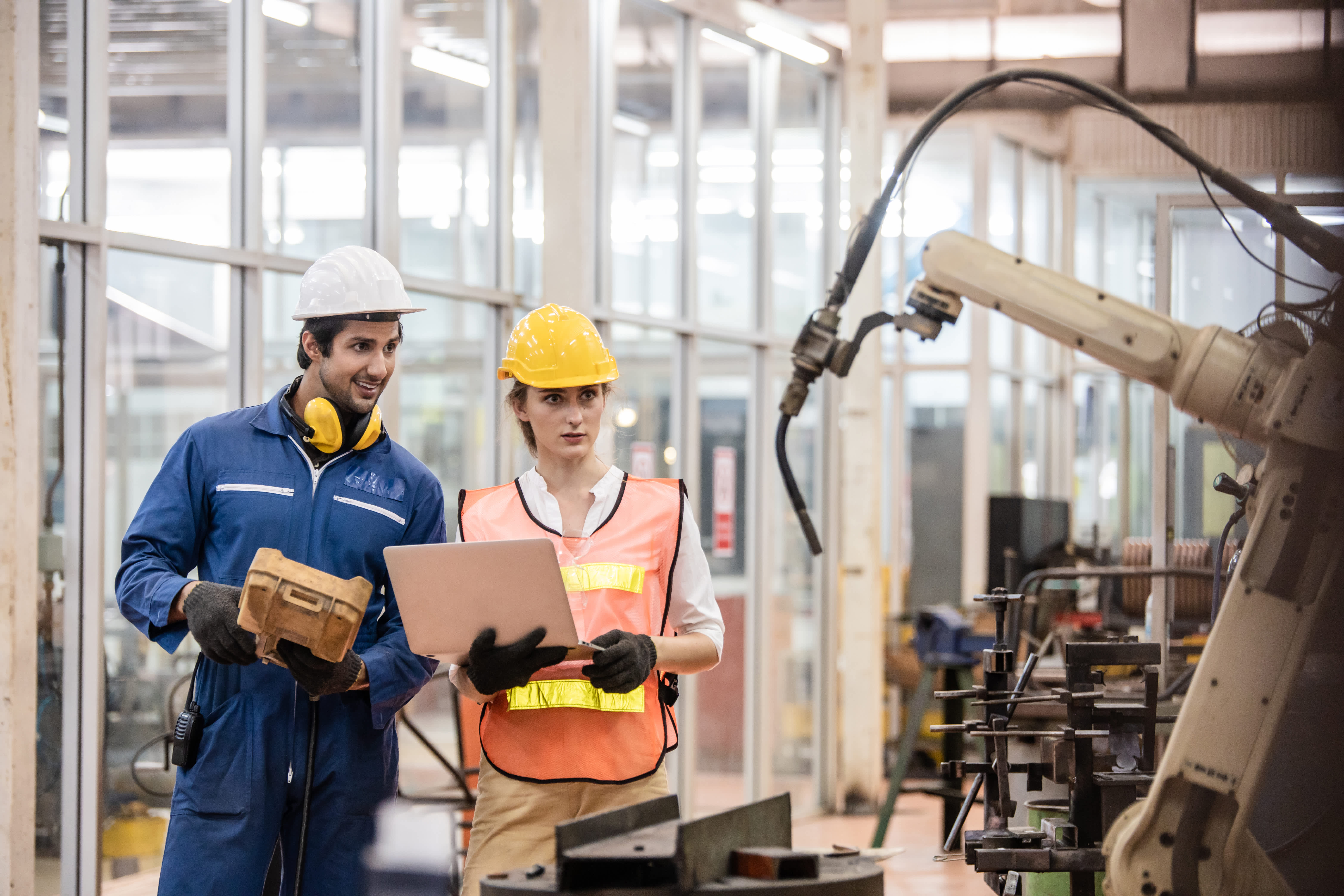 construction workers looking at robot while holding laptop