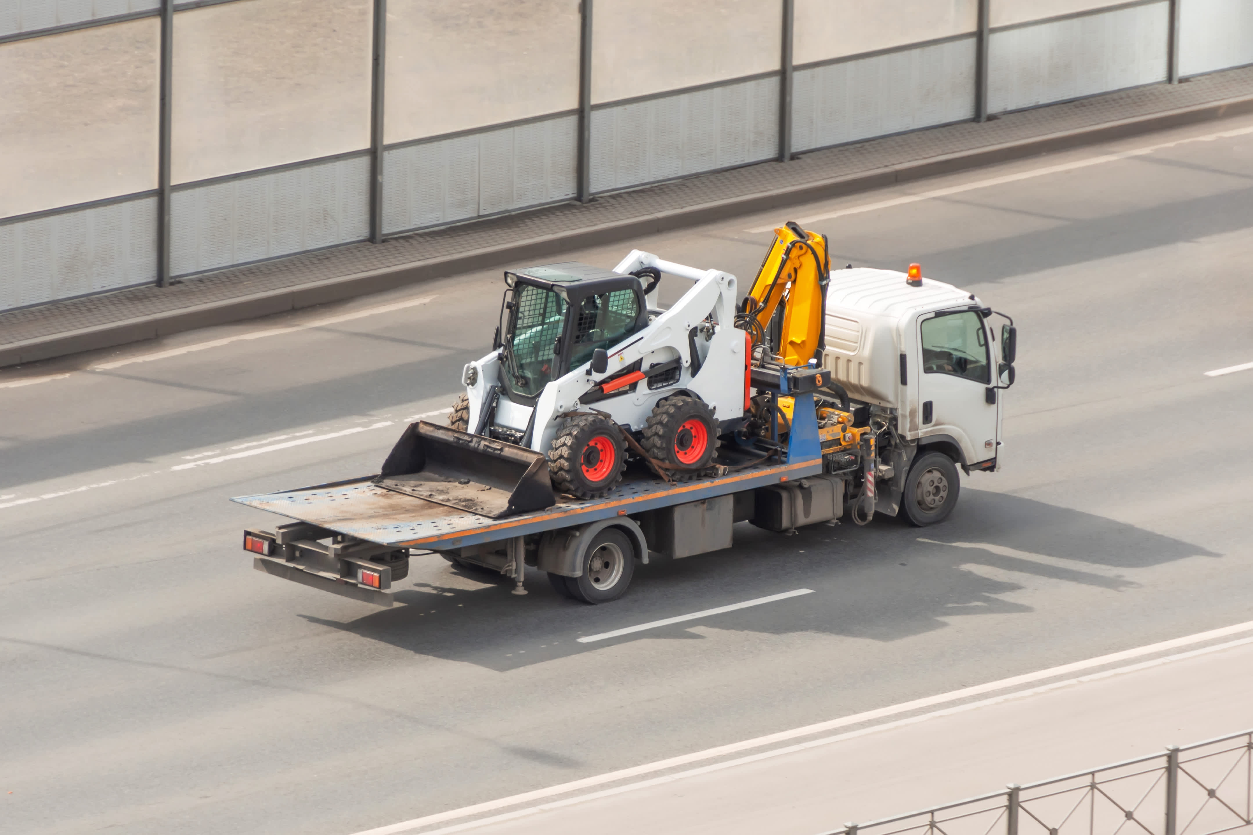 construction equipment on flat bed of truck being delivered